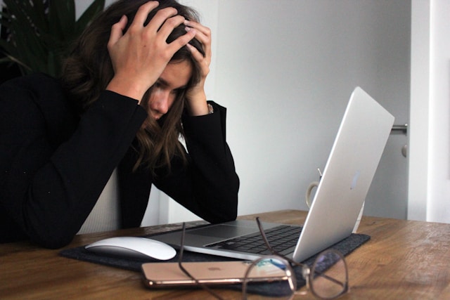 Eine verzweifelt aussehende Frau vor einem PC
